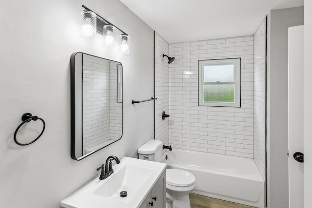 full bathroom with vanity, tiled shower / bath, and toilet