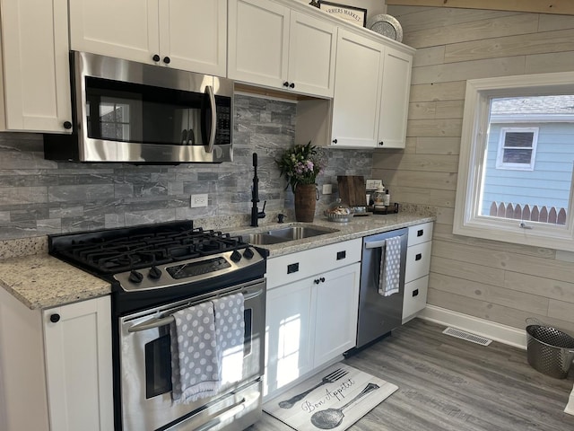 kitchen featuring sink, light stone countertops, white cabinets, and stainless steel appliances