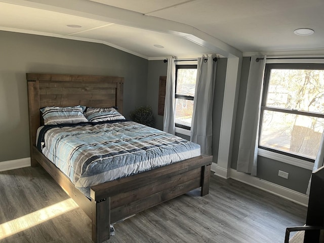 bedroom with lofted ceiling, wood-type flooring, and multiple windows