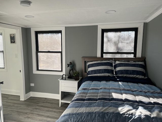 bedroom with ornamental molding and dark hardwood / wood-style floors