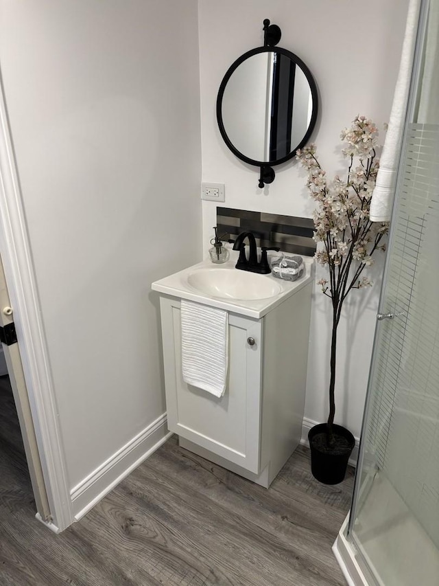 bathroom with vanity, wood-type flooring, and a shower with door