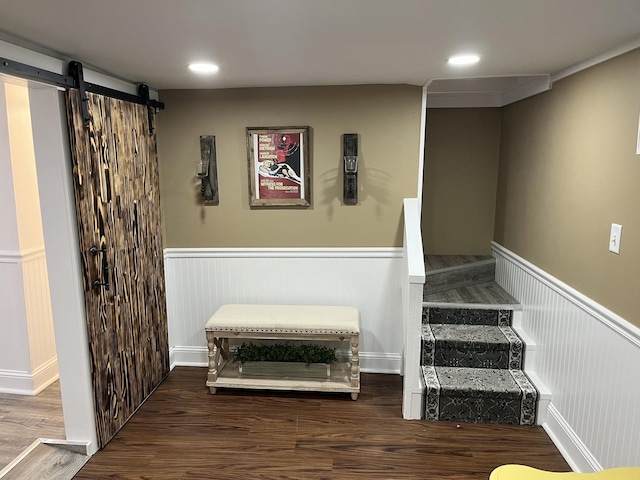 stairs featuring a barn door, crown molding, and hardwood / wood-style floors