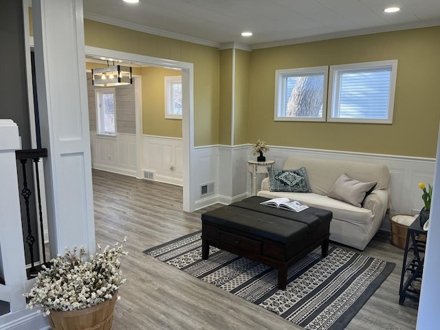 living room featuring plenty of natural light, ornamental molding, and hardwood / wood-style flooring