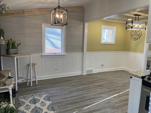 unfurnished dining area featuring dark wood-type flooring and a notable chandelier