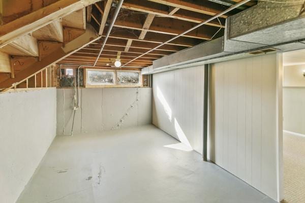 basement featuring wood walls