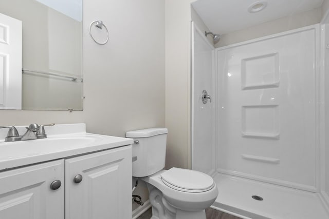 bathroom featuring vanity, toilet, and walk in shower