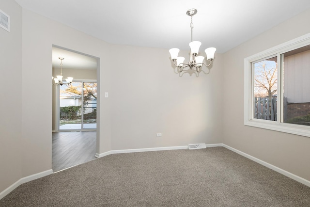 carpeted spare room featuring a healthy amount of sunlight, a water view, and a chandelier