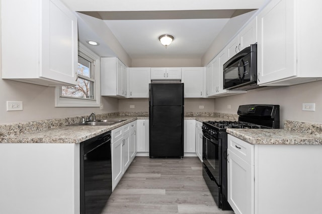 kitchen with white cabinets, sink, light hardwood / wood-style flooring, and black appliances