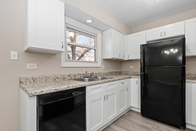 kitchen featuring white cabinets, sink, light hardwood / wood-style floors, and black appliances