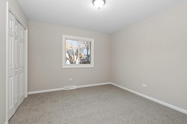 unfurnished bedroom featuring carpet and a closet