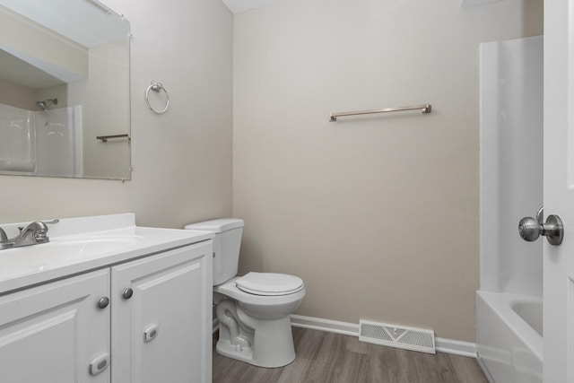 full bathroom with washtub / shower combination, vanity, wood-type flooring, and toilet