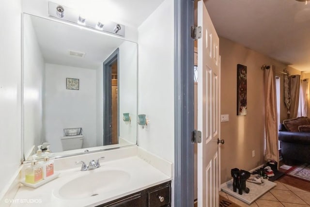 bathroom featuring tile patterned flooring, vanity, and toilet