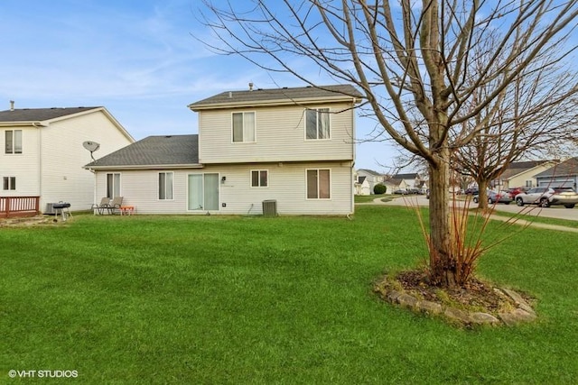 back of house featuring a lawn and central air condition unit