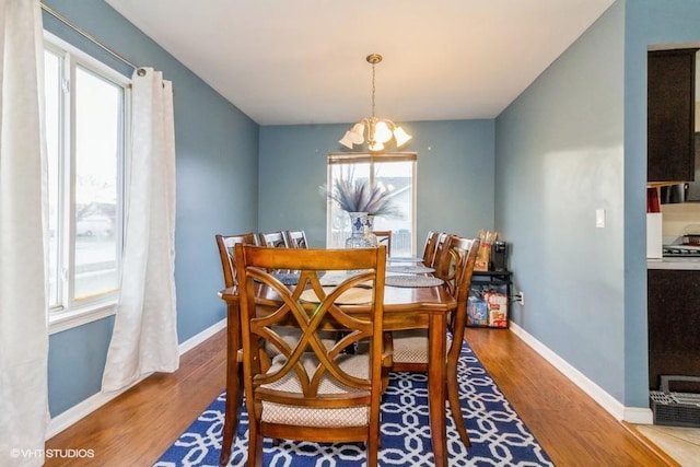 dining space with a notable chandelier and wood-type flooring