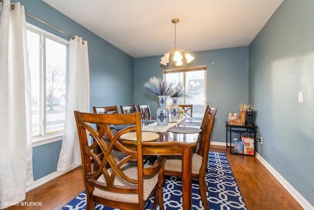 dining space with a notable chandelier, plenty of natural light, and dark hardwood / wood-style floors