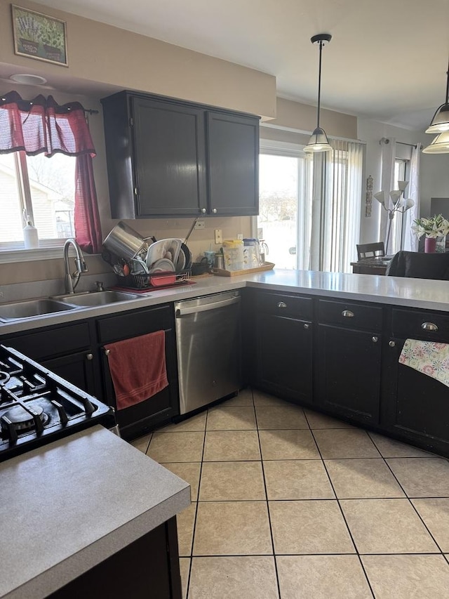 kitchen with decorative light fixtures, dishwasher, sink, and light tile patterned floors