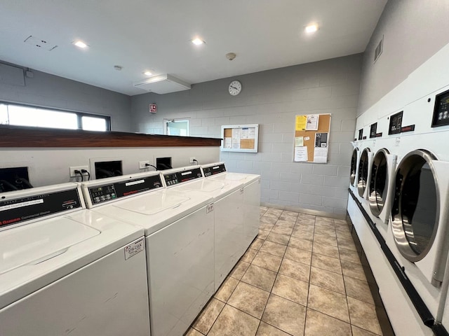 laundry area with separate washer and dryer and light tile patterned floors