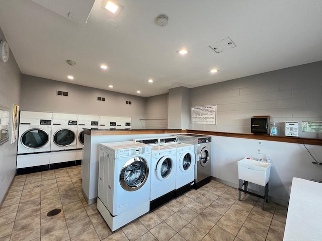 washroom with washing machine and clothes dryer and light tile patterned floors