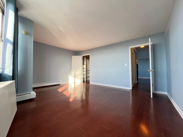 unfurnished room with dark hardwood / wood-style flooring and a baseboard radiator