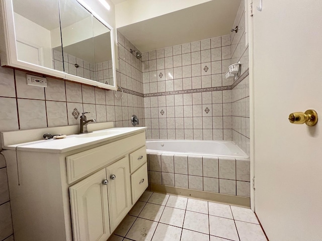 bathroom with tiled shower / bath combo, tile patterned floors, decorative backsplash, vanity, and tile walls