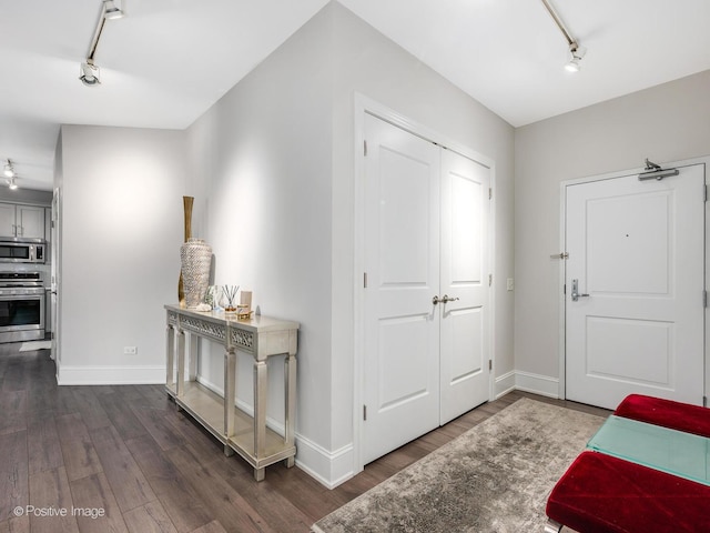 entryway with dark hardwood / wood-style flooring and track lighting