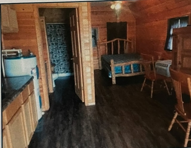 bedroom featuring dark hardwood / wood-style flooring, water heater, and wood walls