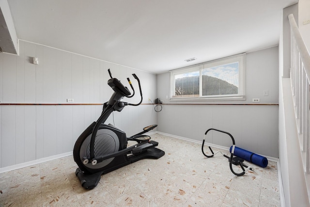 workout room featuring wood walls