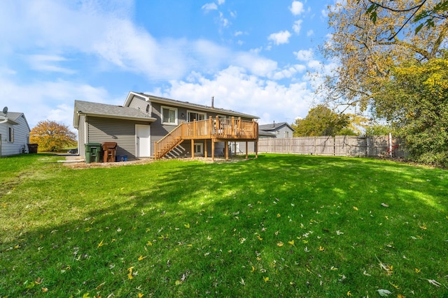 back of property featuring a wooden deck and a yard