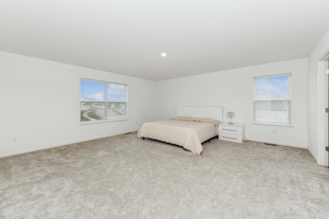 bedroom featuring multiple windows and light carpet