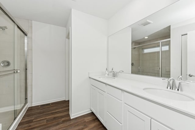 bathroom with wood-type flooring, vanity, and an enclosed shower