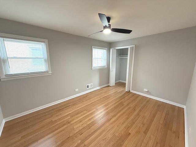 unfurnished bedroom with light wood-type flooring, a closet, and ceiling fan