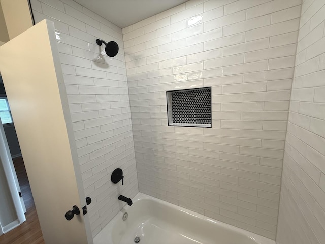 bathroom featuring hardwood / wood-style flooring and tiled shower / bath