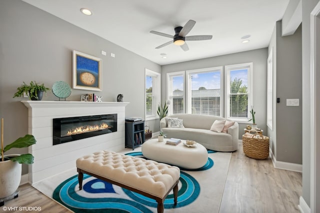 living area featuring light wood-type flooring and ceiling fan