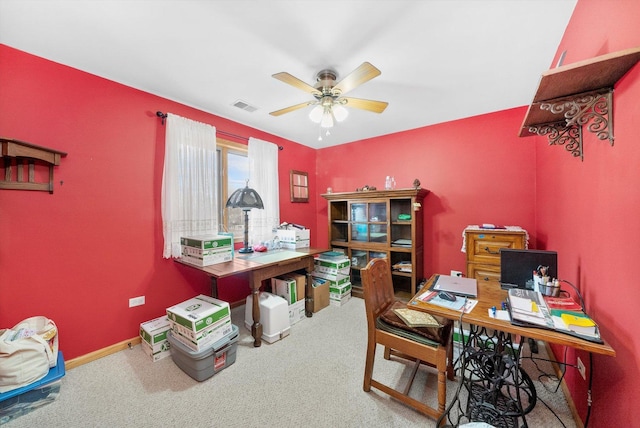 carpeted home office featuring ceiling fan