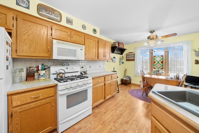 kitchen with ceiling fan, sink, light hardwood / wood-style flooring, white appliances, and decorative backsplash