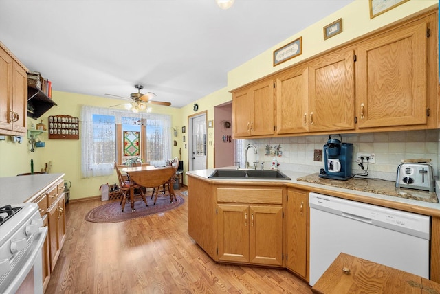 kitchen with white appliances, backsplash, sink, light hardwood / wood-style flooring, and ceiling fan