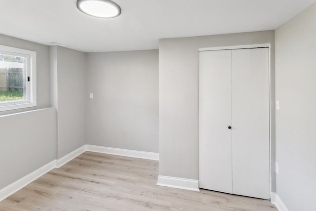 unfurnished bedroom featuring light wood-type flooring and a closet