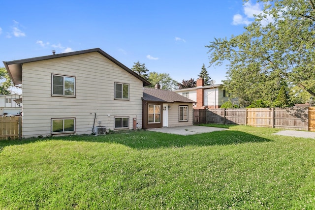 back of property featuring a yard, central AC unit, and a patio area