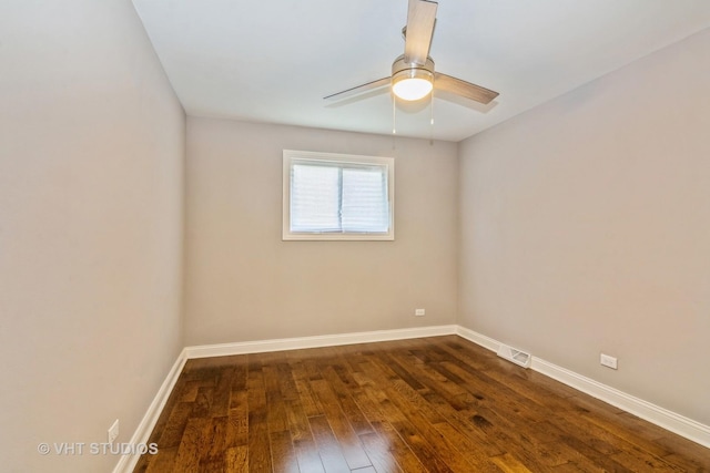 spare room with dark wood-type flooring, baseboards, visible vents, and ceiling fan