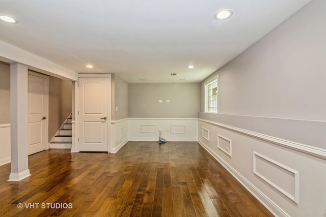 empty room featuring recessed lighting, dark wood-style flooring, and stairs