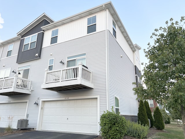 back of property featuring central AC unit and a garage