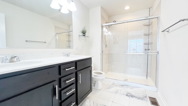 bathroom featuring tile patterned floors, vanity, an enclosed shower, and toilet