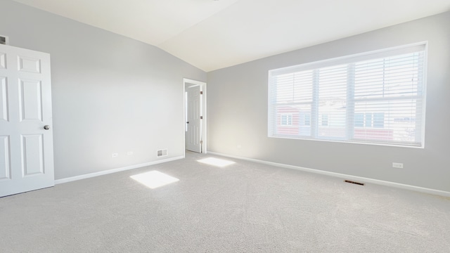 carpeted spare room featuring lofted ceiling