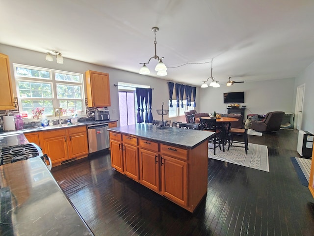 kitchen with ceiling fan, a center island, sink, hanging light fixtures, and stainless steel dishwasher