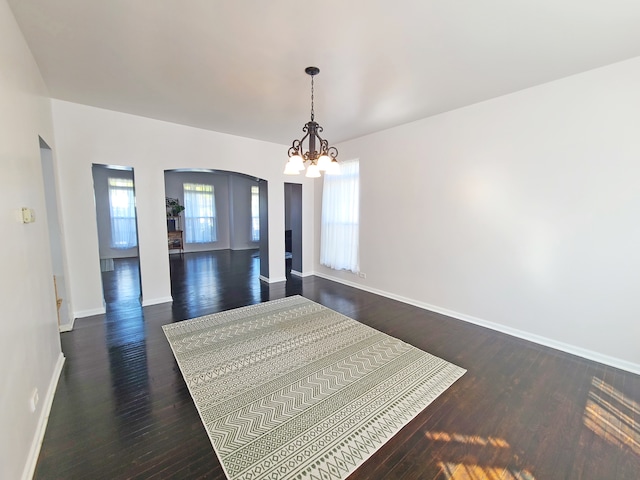 interior space with dark hardwood / wood-style floors, an inviting chandelier, and plenty of natural light