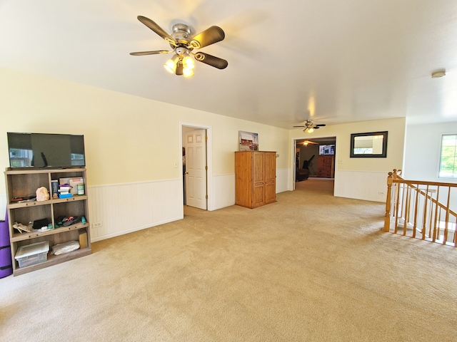 carpeted living room with ceiling fan