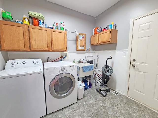 washroom featuring washer and dryer, cabinets, and sink