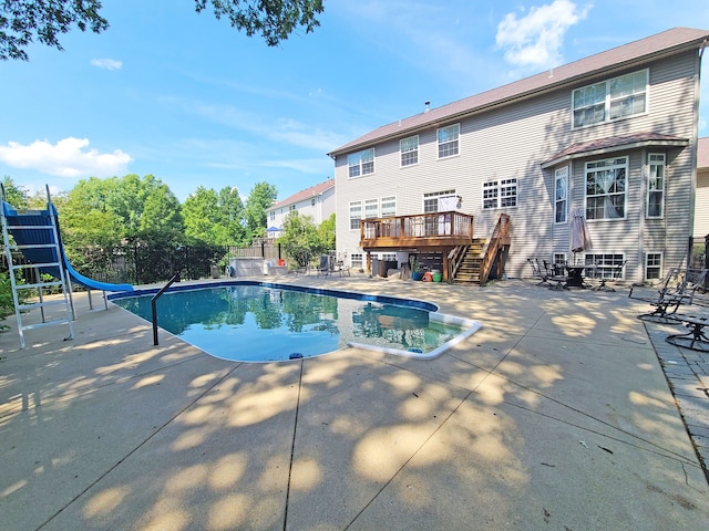 view of swimming pool with a patio area, a water slide, and a deck