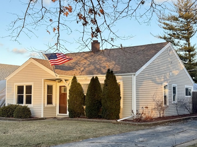 cape cod home with a front lawn