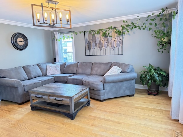 living room featuring a chandelier, light hardwood / wood-style floors, and crown molding